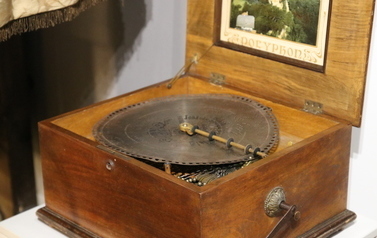 Wystawa stała 'Historia Wronek (od) nowa' - drewniany instrument muzyczny w skrzyni z płytą metalową, na korbkę.